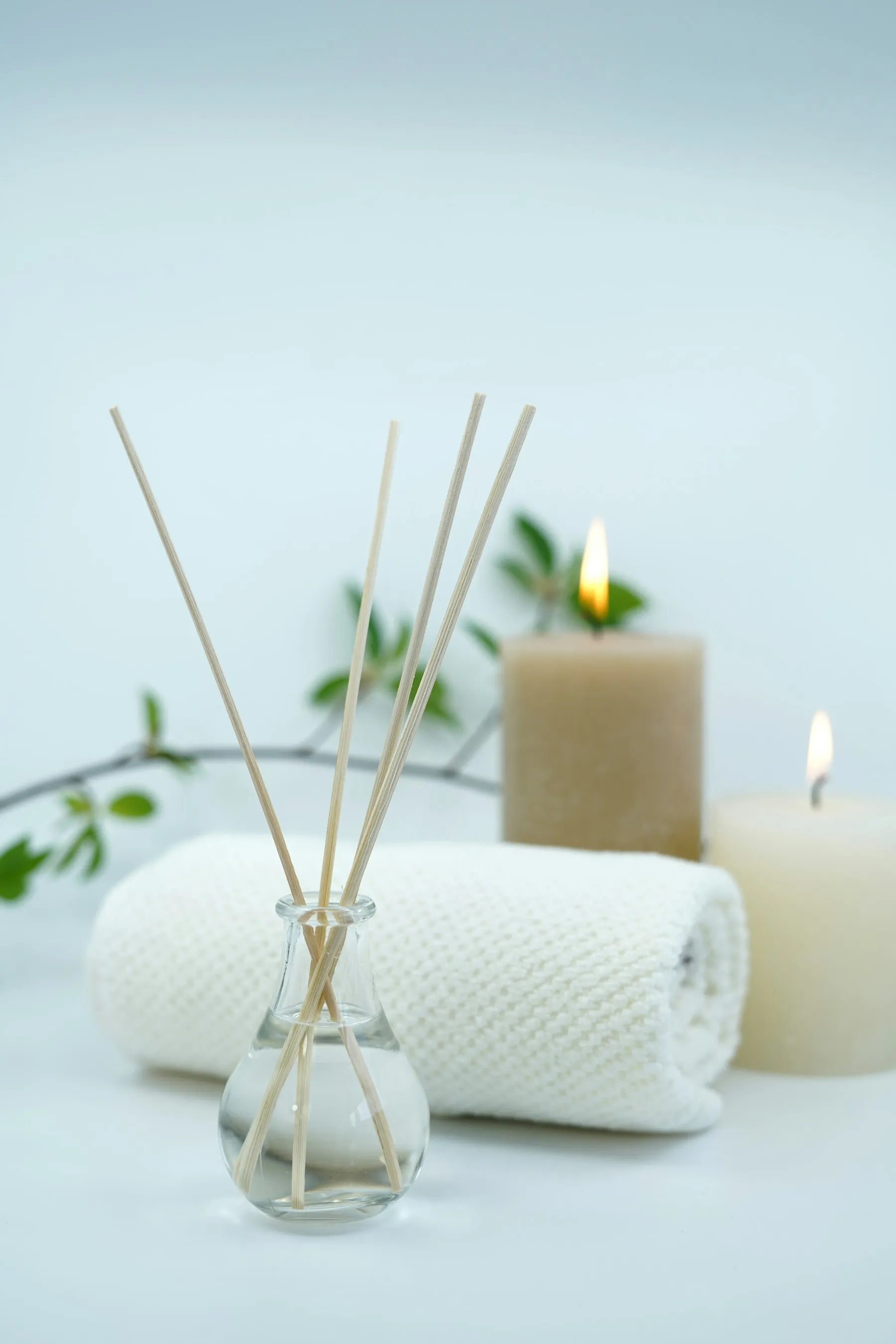 Calm treatment room ambiance with a reed diffuser, candles, and rolled towel