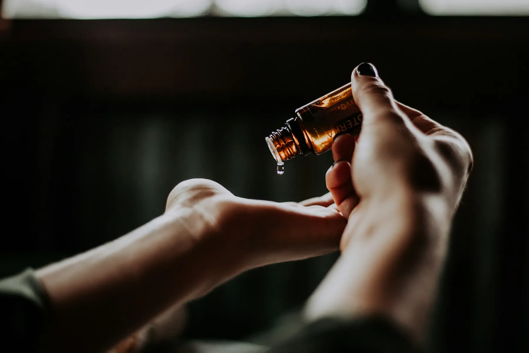 Therapist warming aromatherapy massage oil between their hands