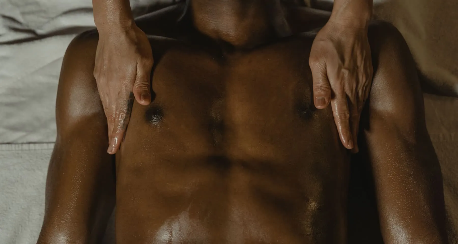 Therapist's hands working a client's chest and shoulders during a customized bodywork session
