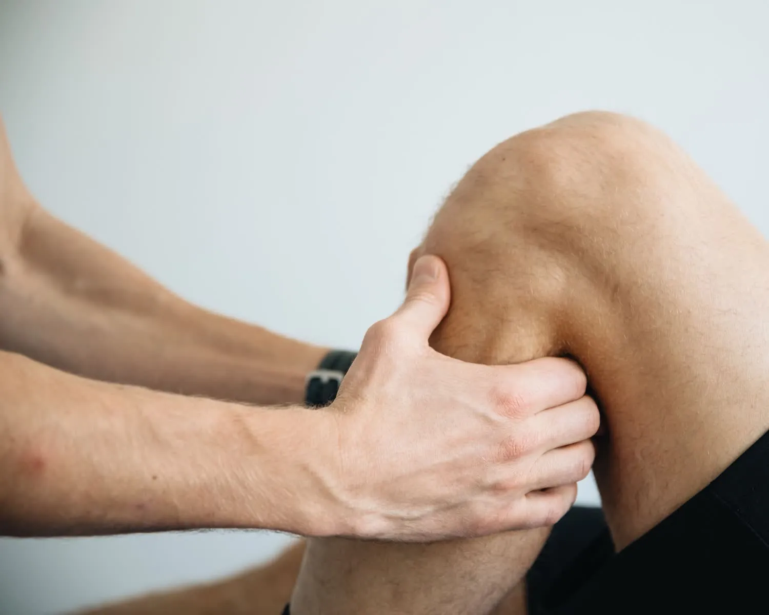 Therapist performing focused sports massage work on a client's knee